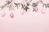 Easter Composition with Olive Branch and Easter Decoration on Pastel Pink Background