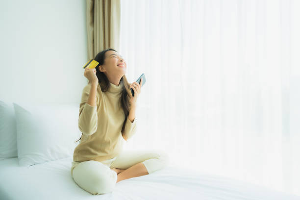 istock Young asian woman using smart mobile phone on bed 1203258646
