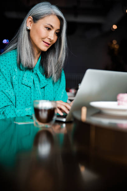 istock Elegant woman working on notebook in cafe 1203264415