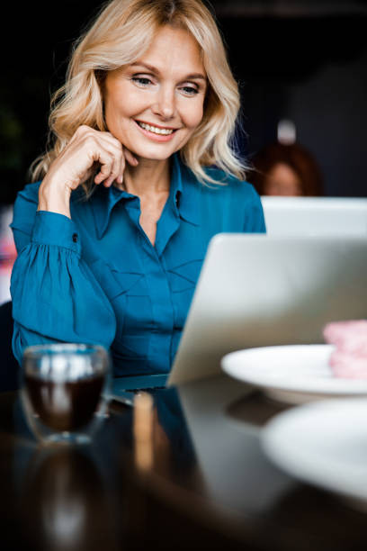 istock Charming woman using modern laptop in cafe 1203264436
