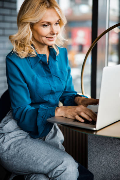 istock Elegant smiling woman working on modern notebook 1203264538