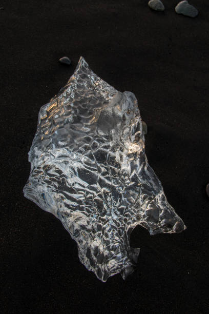 a picture of Ice chunks washed up on a black sand beach