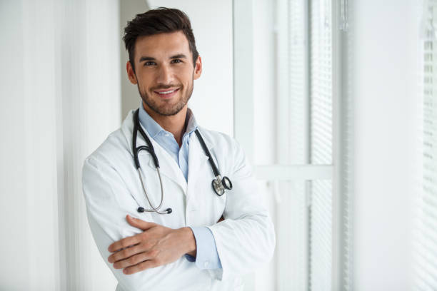 istock Young male doctor smiling and looking at camera 1203266932