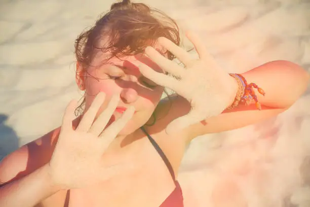 Photo of Protection of the skin from ultraviolet radiation on vacation. A young woman in the summer sun.