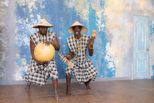 artistes africains jouant des tambours et des instruments de musique - nigeria african culture dress smiling photos et images de collection