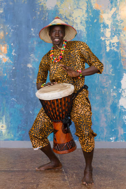 istock African man in traditional clothes playing djembe drum 1203267567