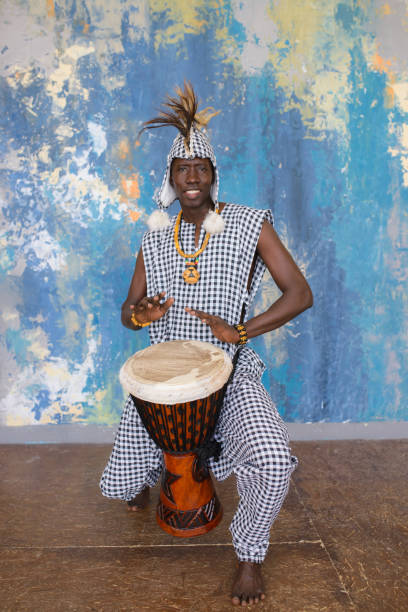 istock African artist in traditional clothes playing djembe drum 1203267608