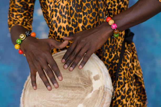 African male hands playing on jembe drum, closeup.