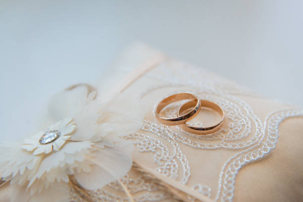 istock Two golden wedding rings on a lace pad 1203267654