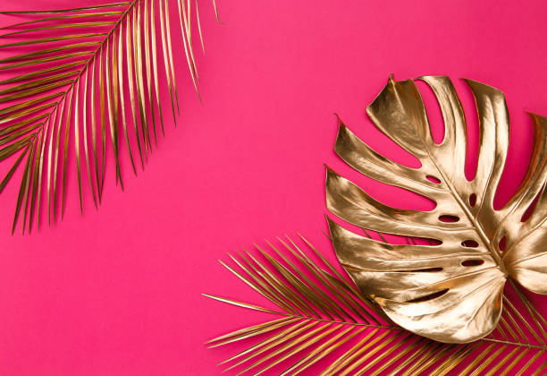 istock Golden tropical leaves on pink background 1203268463