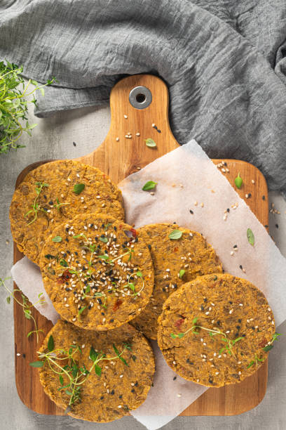 istock Raw veggie burger with lentils, vegetables and thyme leaves on kitchen countertop. Top view. Flat lay 1203269239