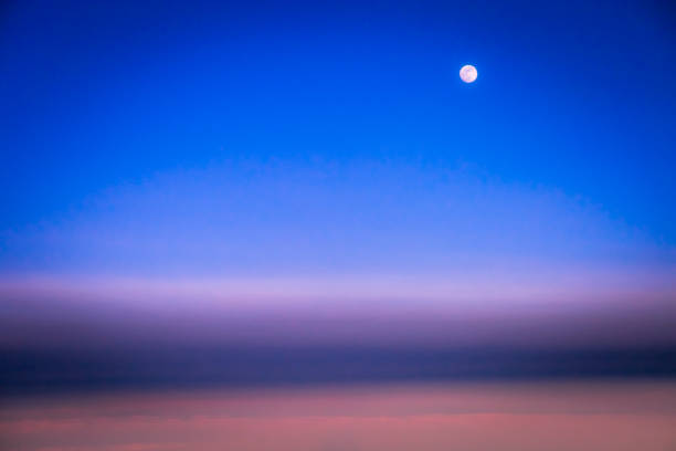 Dramatic Sky above clouds and full moon from airplane window – Usa, North America