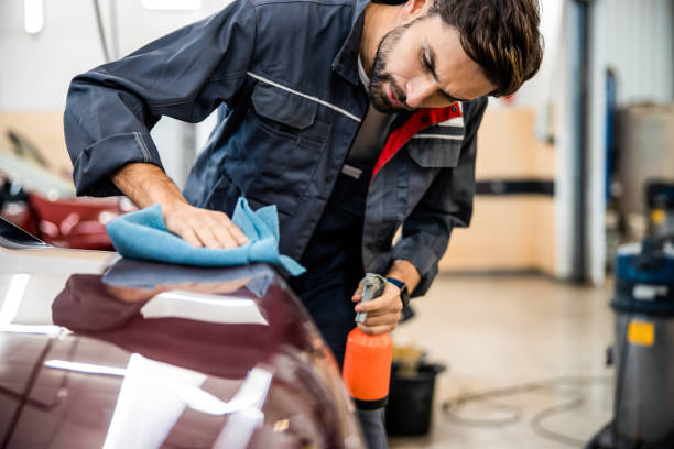 istock Young man cleaning an automobile for a customer 1203273850