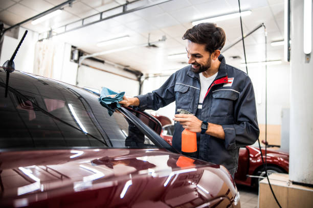 istock Male worker spraying water on a windscreen 1203273857