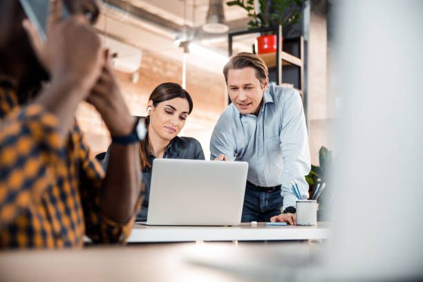 istock Busy international worker sitting on the foreground 1203280070