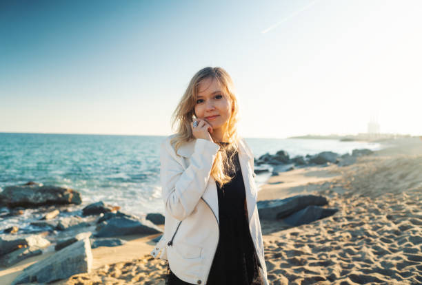 istock Young woman walking at beautiful ocean beach on sunset 1203285245