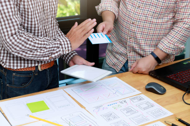 istock Graphic designers work together with UX UI designer planning application template layout framework for mobile phone computer mobile 1203287315