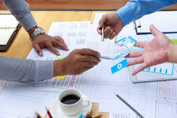 istock Graphic designers work together with UX UI designer planning application template layout framework for mobile phone computer mobile 1203287385