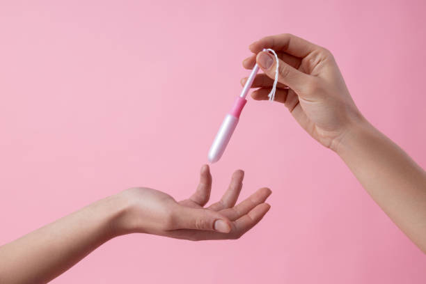 mãos de mulheres passando absorvente umas para as outras foto de estoque - tampon - fotografias e filmes do acervo