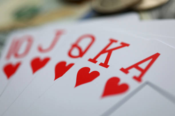 Playing cards lying at money stake with royal flush combination close-up