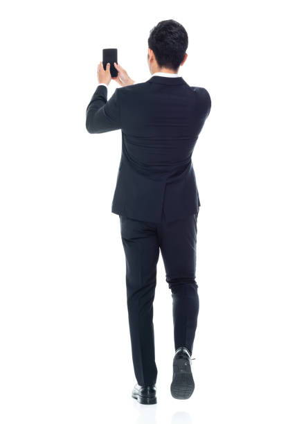 istock Young male businessman walking and using smart phone 1203293644