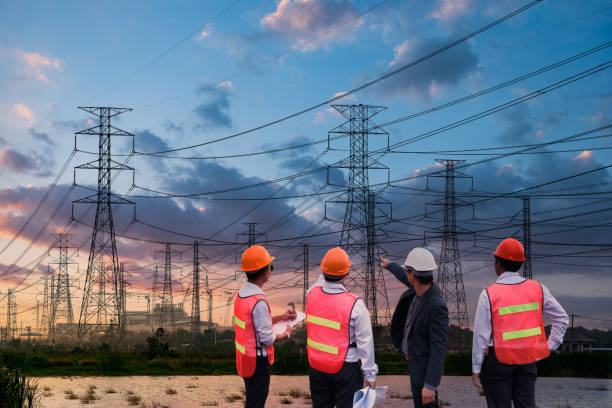 High voltage electric tower. Silhouette high voltage electric tower and engineer team on sunset time and sky on sunset time background. Electrical Power Engineering stock pictures, royalty-free photos & images
