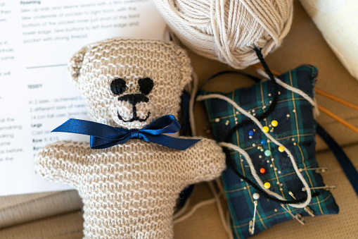Knitted teddy for baby grandson under loving construction by grandmother