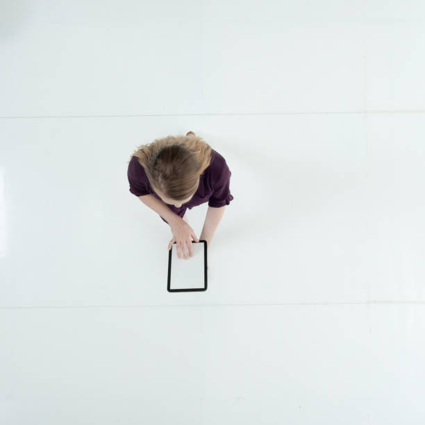 istock Caucasian female walking wearing dress and using touch screen 1203297188