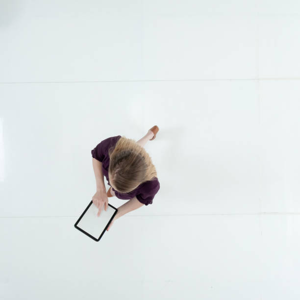 istock Caucasian female walking wearing dress and using touch screen 1203297190
