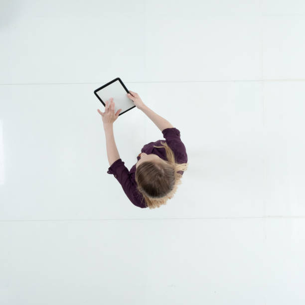 istock Caucasian female standing wearing dress and using touch screen 1203297236