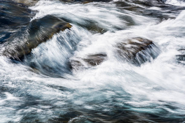 istock Creek or stream water flowing past rocks and stones 1203297695