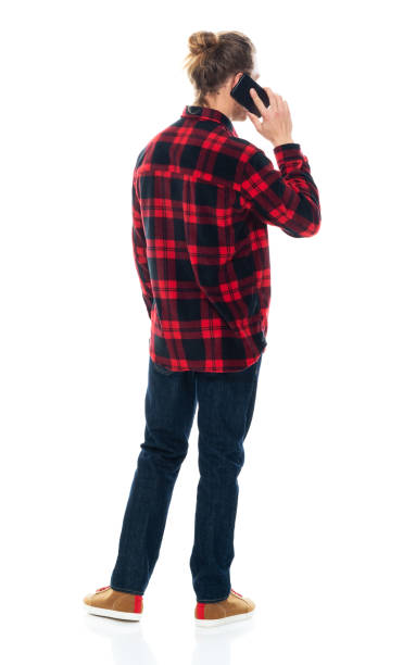 istock Caucasian young male standing wearing jeans and using mobile phone 1203298624