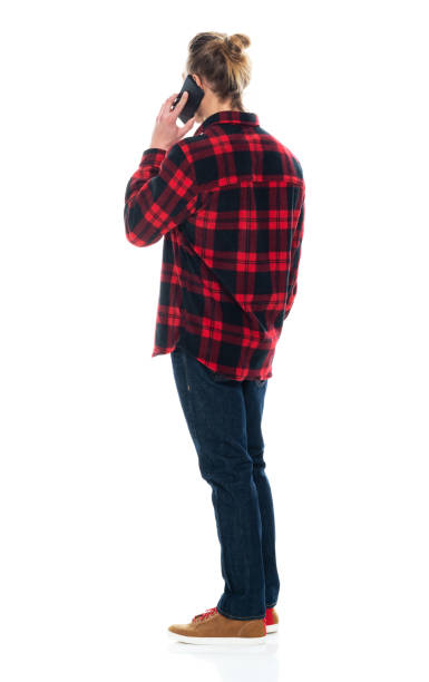 istock Caucasian male standing wearing jeans and using smart phone 1203298778