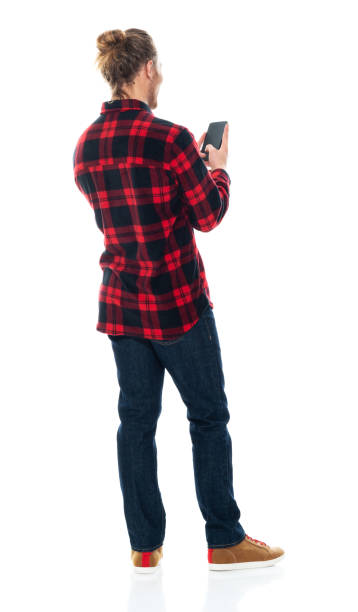 istock Caucasian male standing wearing jeans and using smart phone 1203298803