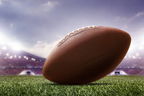 photo american football ball on stadium background stock photo