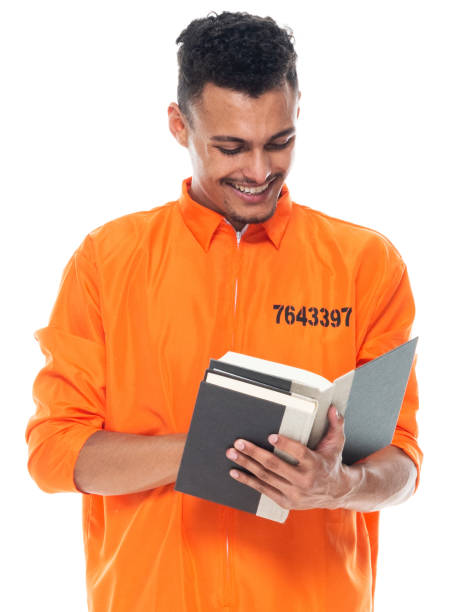 istock Generation z young male university student standing wearing jumpsuit and holding textbook 1203301240
