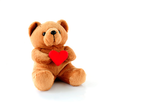 Teddy Bear Holding a heart-shaped on white background\