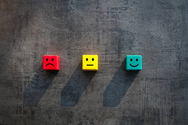 Customer business satisfaction ratings concept with traffic light coloured wood blocks with facial expressions and copy space stock photo