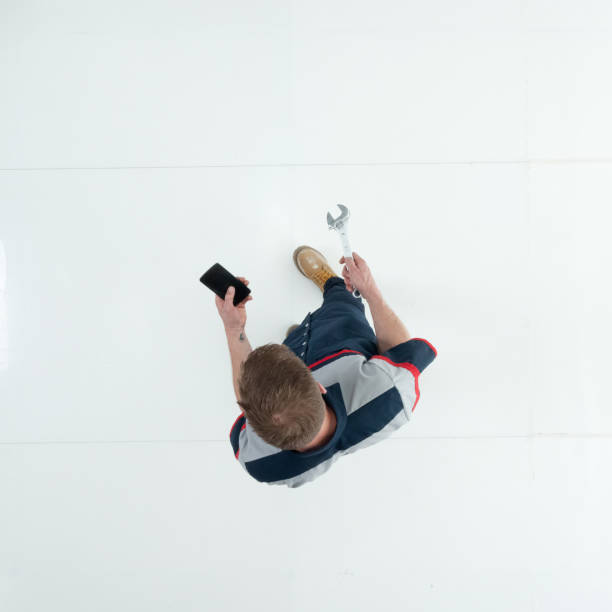 istock Caucasian young male technician standing wearing uniform and holding open end wrench and using smart phone 1203304502
