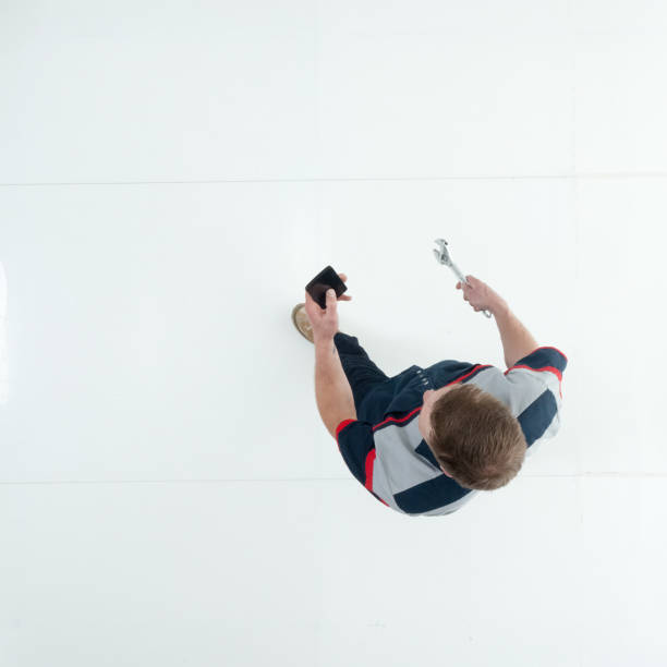 istock Caucasian young male technician walking wearing uniform and holding open end wrench and using smart phone 1203304508