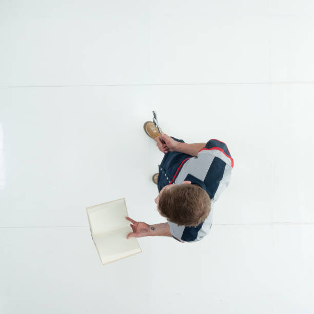 istock Caucasian young male student standing wearing uniform and holding textbook 1203304511