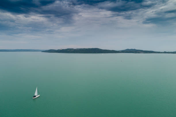 White sailing boat in Lake Balaton with cloud sky