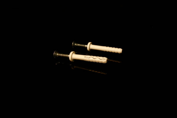 istock two wall dowel pin with screw isolated on black with reflections 1203314069