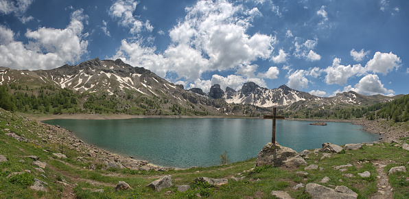 The Mercantour National Park is located in the French Alps. A mountain lake lies between the snowy mountains