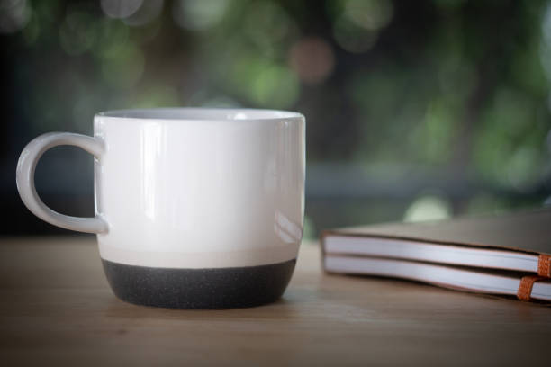 istock White ceramic cup and book on white table. Have a relax sunday. 1203318944