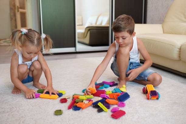 istock Two children playing with blocks on the floor at home 1203321708