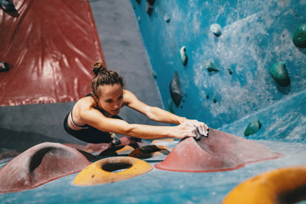 istock Muscular woman on boulder climbing training 1203323877