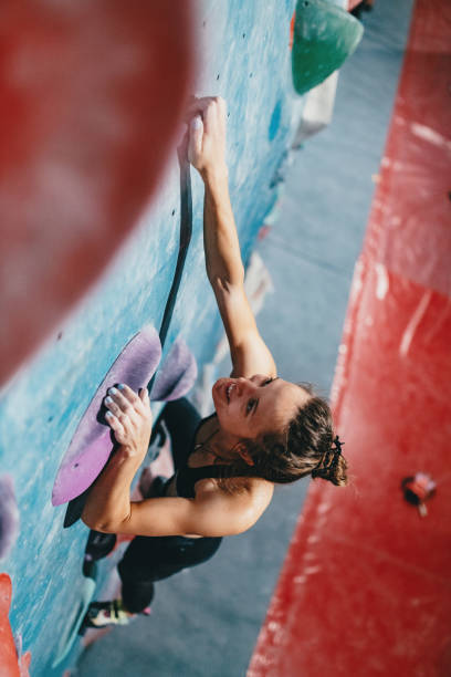 istock Muscular woman on boulder climbing training 1203324631