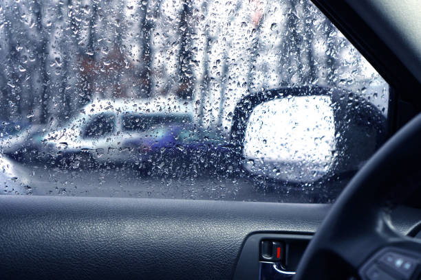 istock Driving in rainy weather. Side window on the driver side with rain drops. 1203326797