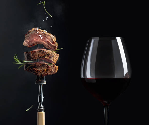 grilled  beef steak with rosemary and glass of red wine on a black background. - food and drink steak meat food imagens e fotografias de stock